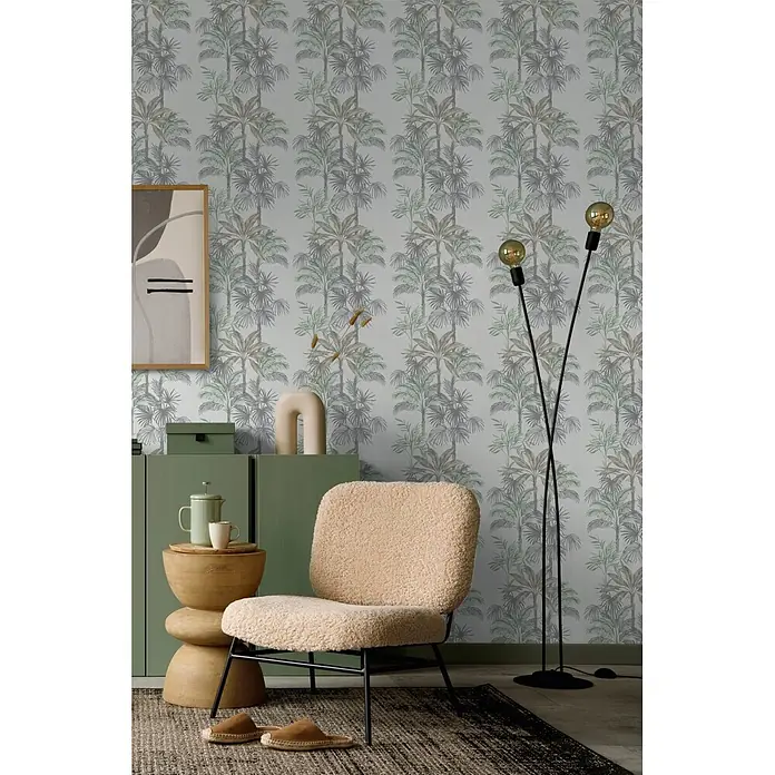 Marburg Vliestapete Novamur Leyla Floral I - Grau-Grün, Floral, 10,05 x 0,53 m - Beiger Sessel aus Teddy-Stoff mit schwarzen Beinen in einem Wohnraum.