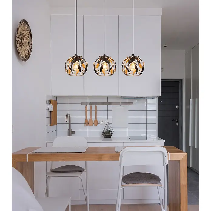 Globo Pendelleuchte Mika - 40 W, L x B x H: 740 x 200 x 1.500 mm, E27 - Drei moderne Pendelleuchten in Schwarz-Gold mit Blattdesign und Kristallakzenten, die einen Essbereich in der Küche beleuchten.