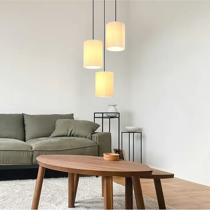 Globo Pendelleuchte Page - 25 W, E27, Pendellänge: 1.200 mm - Drei zylindrische, plissierte Pendelleuchten hängen von der Decke und beleuchten ein modernes Wohnzimmer.
