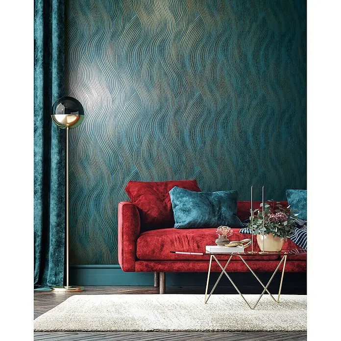 Marburg Vliestapete Novamur Mona Grafik - Grün-Gold, Grafisch, 10,05 x 0,53 m - Petrolfarbene Tapete mit eleganten goldenen Wellenlinien an einer Wohnzimmerwand hinter einem roten Sofa.