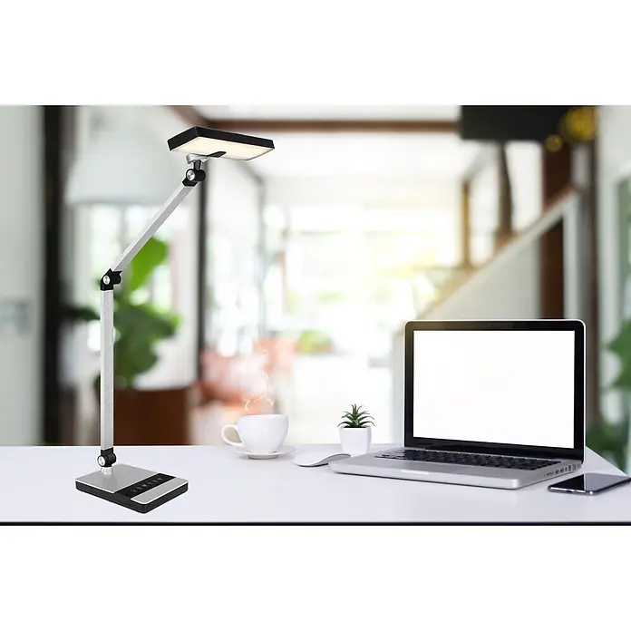 Globo Tischleuchte Dally - 9 W, L x B x H: 400 x 270 x 820 mm - Verstellbare silberne und schwarze LED-Schreibtischlampe, die einen modernen Arbeitsbereich mit Laptop und Kaffeetasse beleuchtet.