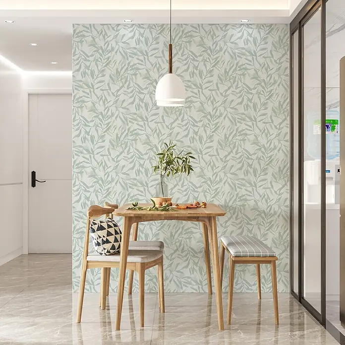 Marburg Vliestapete Novamur Leyla Floral - Weiß-Grün, Floral, 10,05 x 0,53 m - Hellgrüne Blätter-Tapete schmückt einen modernen Essbereich mit Holztisch und Stühlen.