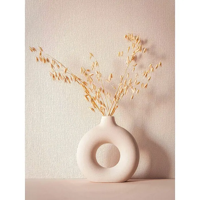 Marburg Vliestapete Novamur Mona Uni - Beige, Uni, 10,05 x 0,53 m - Helle beige, donut-förmige Vase mit getrockneten Haferhalmen auf einer Oberfläche.