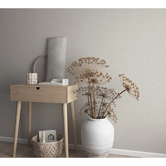 Marburg Vliestapete Novamur Leyla Uni - Grau, Uni, 10,05 x 0,53 m - Strukturierte, hellbeige Tapete mit feinem vertikalem Webmuster an einer Wand.