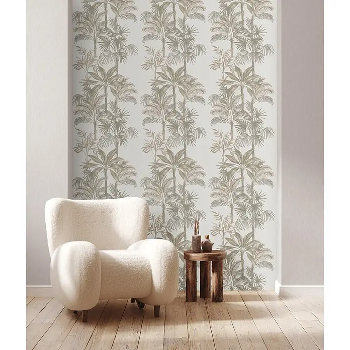 Marburg Vliestapete Novamur Leyla Floral I - Weiß-Beige, Floral, 10,05 x 0,53 m - Tapete mit sich wiederholendem beigem Palmenmuster an einer hellen Wand, neben einem weißen Sessel und einem Holztisch.