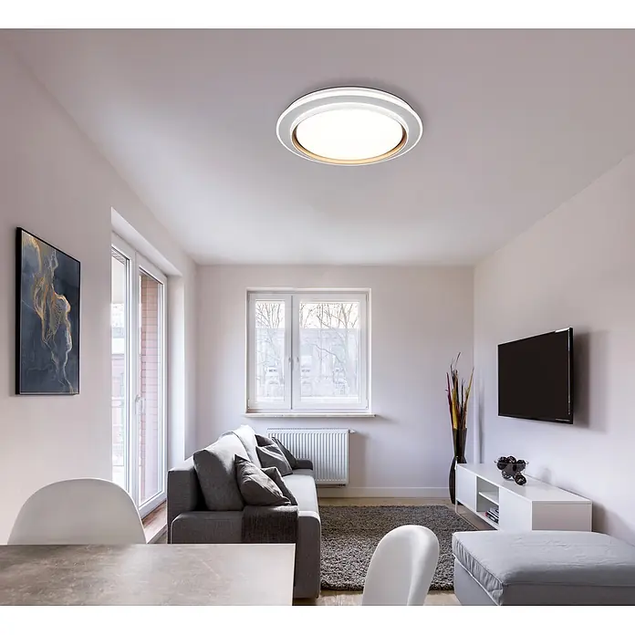 Globo LED-Deckenleuchte rund Janice - 48 W, Ø x H: 490 x 70 mm, Warmweiß - Moderne weiße und silberne Deckenleuchte, die ein Wohnzimmer beleuchtet.