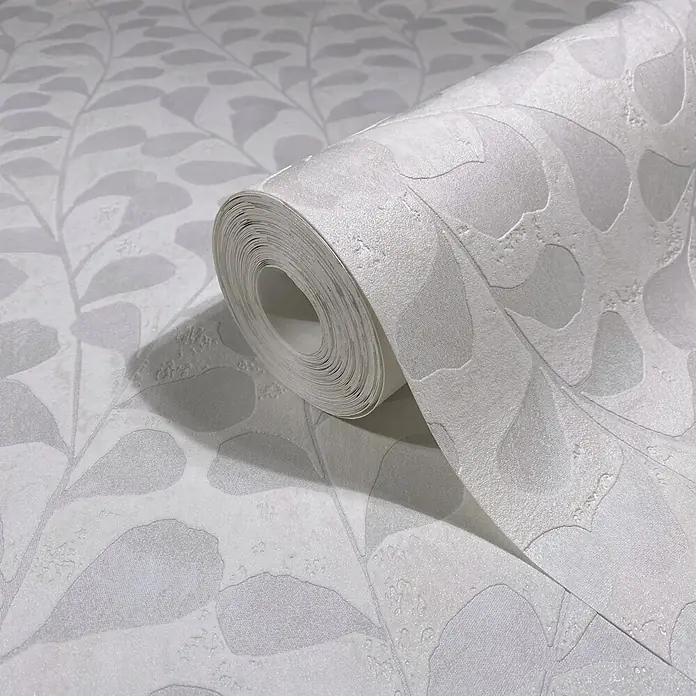 Marburg Vliestapete Novamur Naomi Floral - Weiß, Floral, 10,05 x 0,53 m - Hellgraue Tapetenrolle mit geprägtem Blattmuster, abgerollt, um ihre Textur zu zeigen.