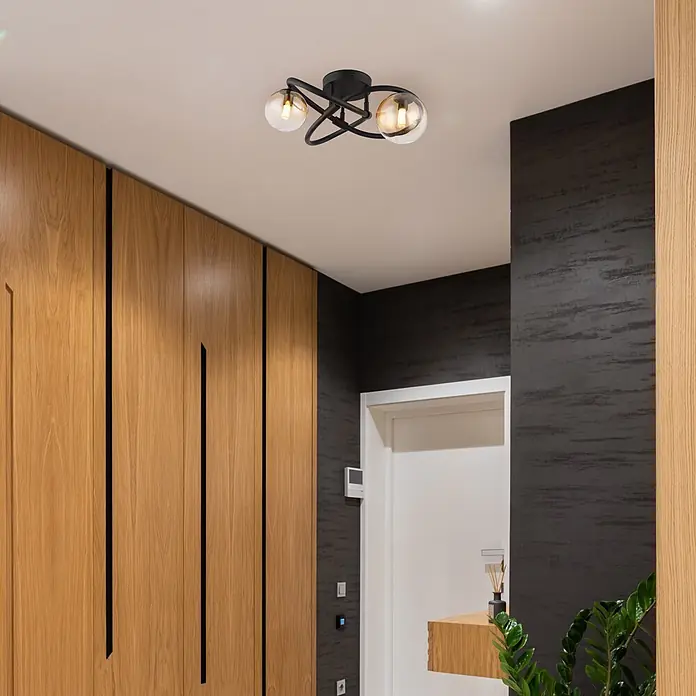 Globo LED-Deckenleuchte Tuberius - 3,5 W, G9 - Moderne schwarze Deckenleuchte mit zwei bernsteinfarbenen Glaskugeln an einer weißen Decke in einem Flur montiert.
