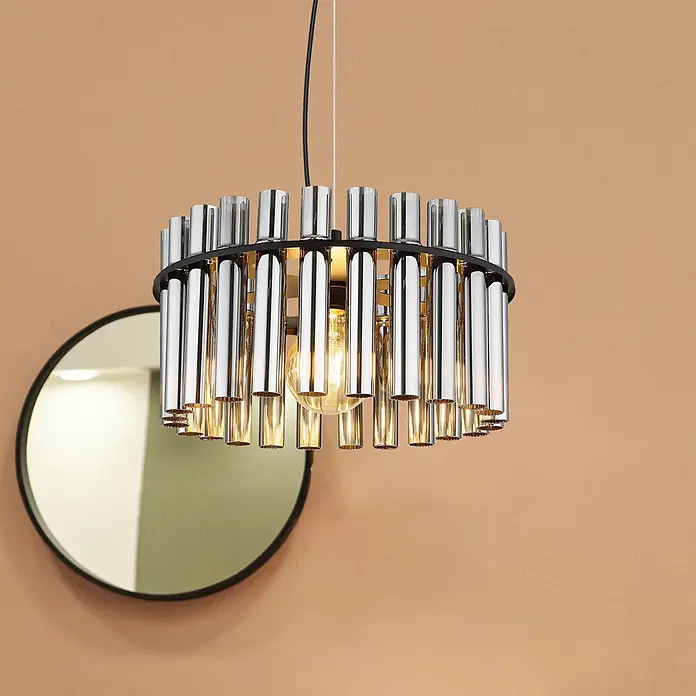 Globo Pendelleuchte rund Gorley - 60 W, Ø x H: 38 x 120 cm, E27 - Chrom- und schwarze Pendelleuchte mit zylindrischen Elementen und sichtbarer Glühbirne, vor einer warmen Wand mit Spiegel.