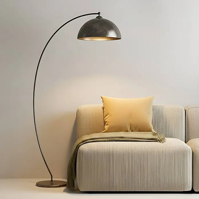 Lindby Stehleuchte Jonera - Höhe: 185 cm, alu / grau / zink, alu / grau / zink, E27 - Bogenförmige Stehlampe mit dunklem Metallkuppelschirm, die ein modernes Sofa beleuchtet.