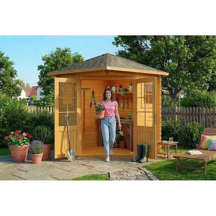 Alpholz Gartenhaus ECO Set Sunny A imprägniert - Außenmaß inkl. Dachüberstand (B x T): 220 x 220 cm, Holz, Pinie - Hölzerner Gartenschuppen, eine Frau kommt mit einer Topfpflanze heraus. Der Schuppen ist mit Gartengeräten und Regalen ausgestattet.