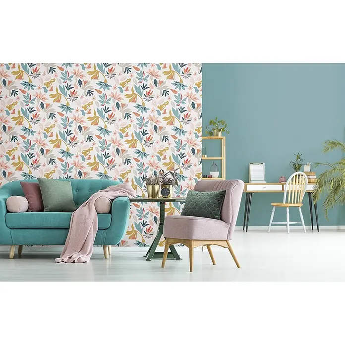 Marburg Flora Vliestapete Floral IV - Weiß-Blau-Rot, Floral, 10,05 x 0,53 m - Ein Wohnzimmer mit bunter Blumen-Tapete, einem tealfarbenen Sofa und einem rosa Sessel, das einen lebendigen, modernen Raum schafft.