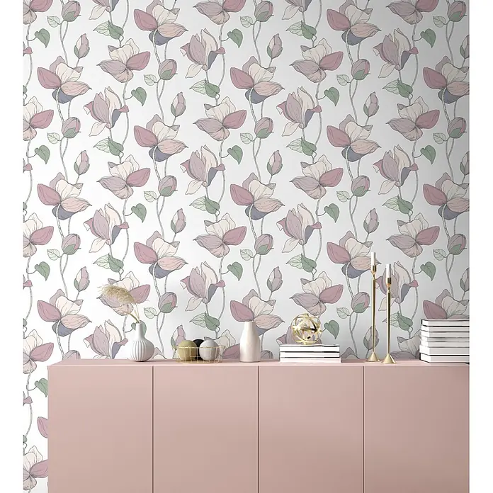 Marburg Flora Vliestapete Flora V - Weiß-Beige, Floral, 10,05 x 0,53 m - Rosa Sideboard-Schrank, mit Dekorationen versehen, vor einer Wand mit zartem Blumenmuster.