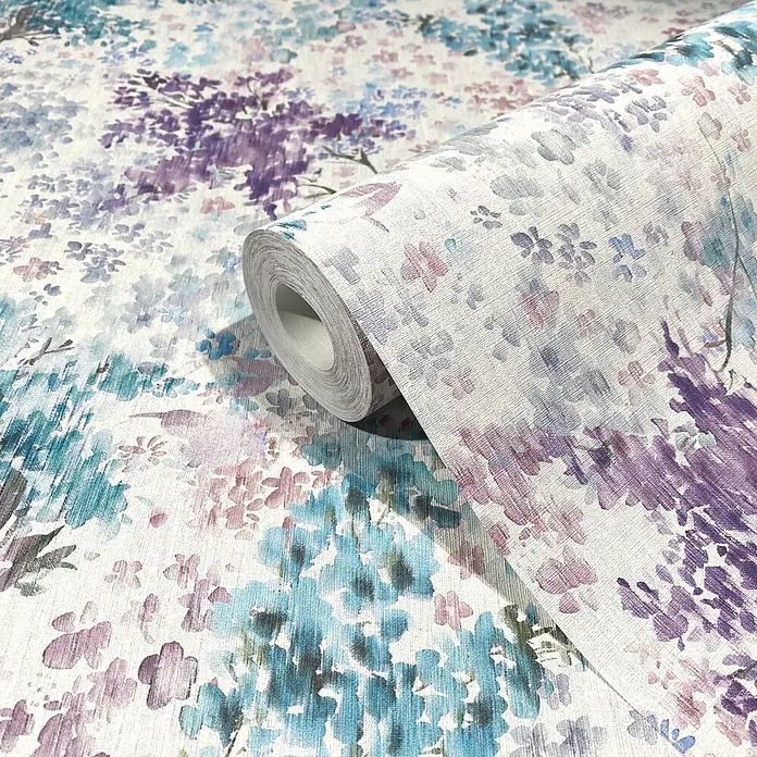 Marburg Flora Vliestapete Floral - Weiß-Blau-Lila, Floral, 10,05 x 0,53 m - Tapetenrolle mit texturiertem, hellem Hintergrund und Aquarell-Blumenmuster in Lila, Blau und Pink, teilweise abgerollt.