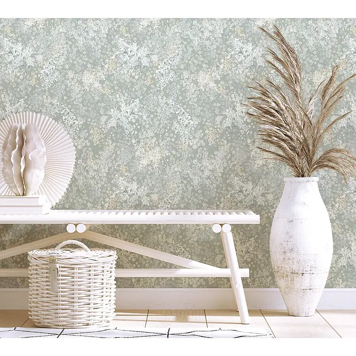 Marburg Flora Vliestapete Floral - Grau-Weiß, Floral, 10,05 x 0,53 m - Salbeigrüntapete mit zarten weißen und beigen Blumenmustern, die eine Wand in einem Raum schmückt.