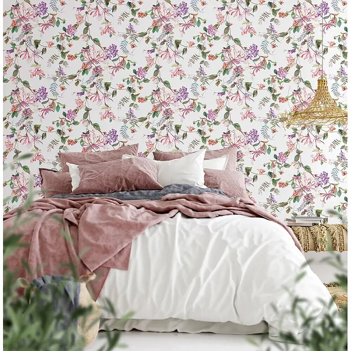 Marburg Flora Vliestapete Floral I - Weiß-Rosa-Grün, Floral, 10,05 x 0,53 m - Lebendige florale Tapete mit rosa, lila und grünen Blüten und Blättern als Akzentwand hinter einem Bett.