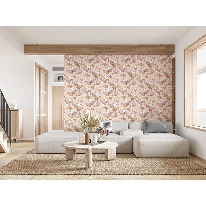 Marburg Flora Vliestapete Flora V - Beige-Braun-Orange, Floral, 10,05 x 0,53 m - Florale Tapete mit großen rosa, weißen, braunen und gelben Magnolienblüten auf hellrosa Grund, schmückt eine Wohnzimmerwand hinter einem Sofa.