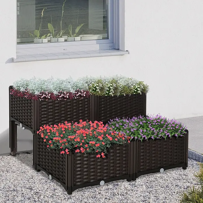Outsunny Hochbeet 4-tlg. - 40 x 40 x 44 cm, Kunststoff, Braun - Gestuftes dunkelbraunes Geflecht-Pflanzsystem mit bunten Blumen, im Außenbereich an einem Haus.