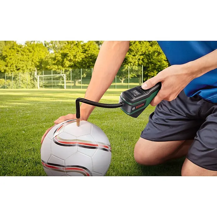 Bosch Akku-Luftpumpe Pneo Fahrradtasche - 3,6 V, Max. Druck: 10,3 bar - Schwarz-grüner Bosch EasyPump Inflator pumpt einen weißen Fußball auf.
