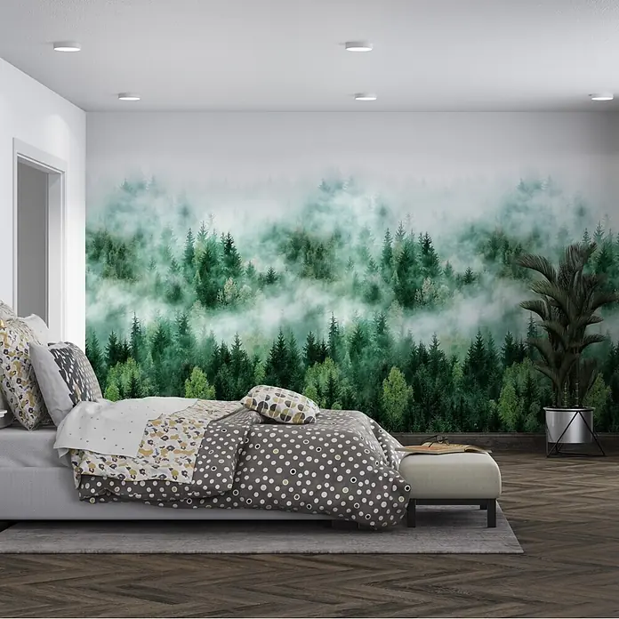 Marburg Smart Art Easy Fototapete Wald - B x H: 159 mm x 270 cm, Vlies, Grün - Schlafzimmer mit Bett, grau-weiß gepunkteter Bettwäsche, geometrischen Zierkissen und hellgrauem Polsterrahmen vor einer nebeligen Waldtapete.