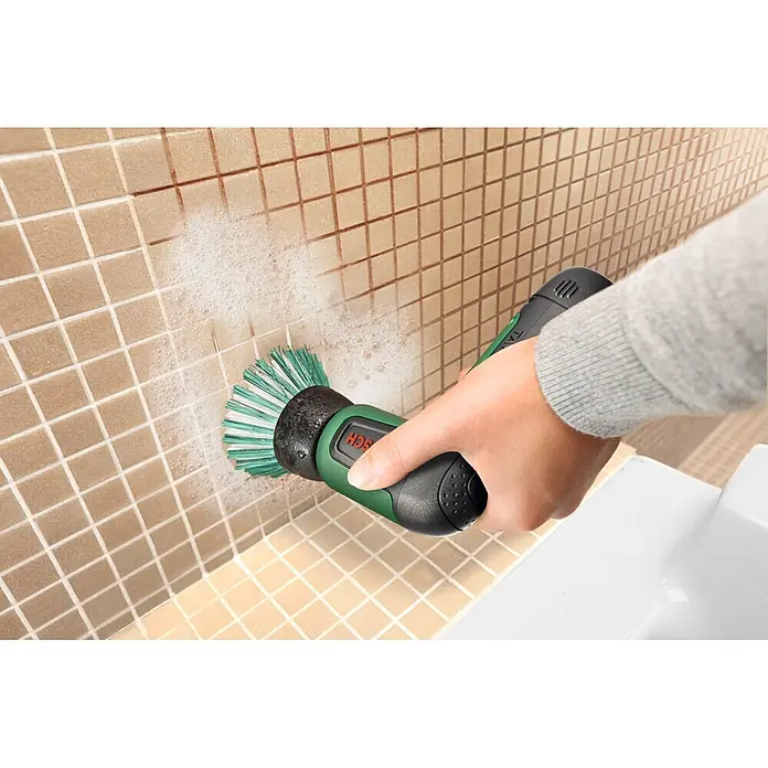 Bosch Akku-Reinigungsbürste Taydo - 3,6 V, 1 Akku, 6 -tlg. - Grün-schwarze elektrische Reinigungsbürste reinigt beige Fliesenwände mit Schaum.