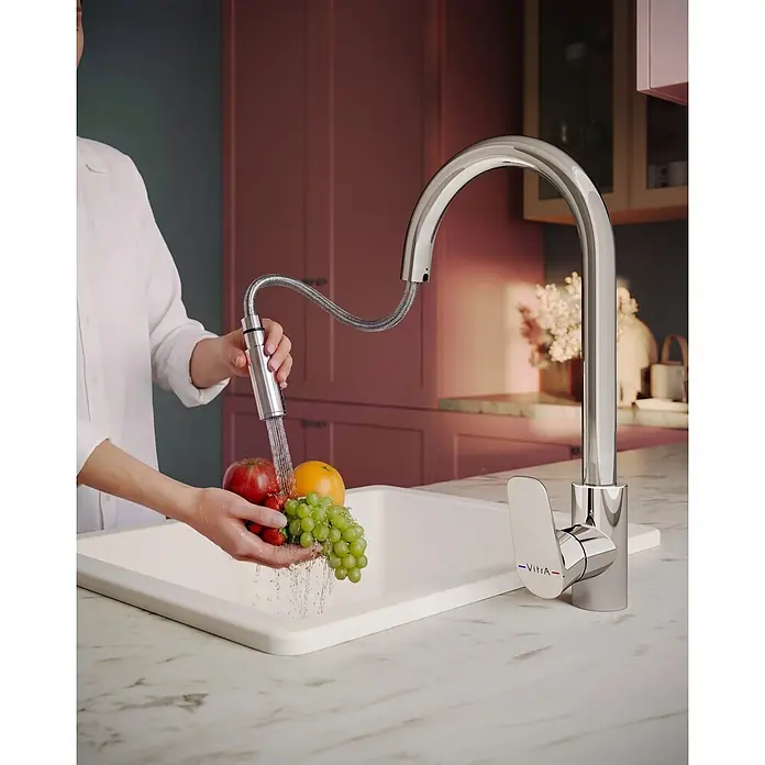 VitrA Flow Soft Spültischarmatur - Ausziehbar, Chrom, Glänzend, Höhe: 39,9 cm - VitrA Chrom-Küchenarmatur mit Ausziehbrause wäscht Obst in einem weißen Spülbecken.