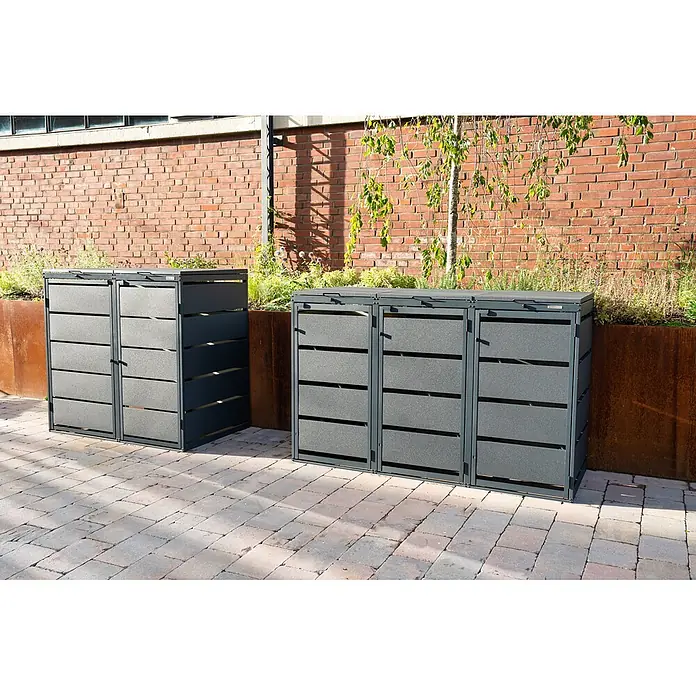 MBOX Mülltonnenbox - Stahl, RAL7016, Geeignet für Anzahl Mülltonnen: 3 Stk. - Dunkelgraue Lamellen-Mülltonnenboxen auf einer Terrasse. Eine Doppel- und eine Dreifach-Einheit stehen neben Pflanzgefäßen an einer Ziegelwand.