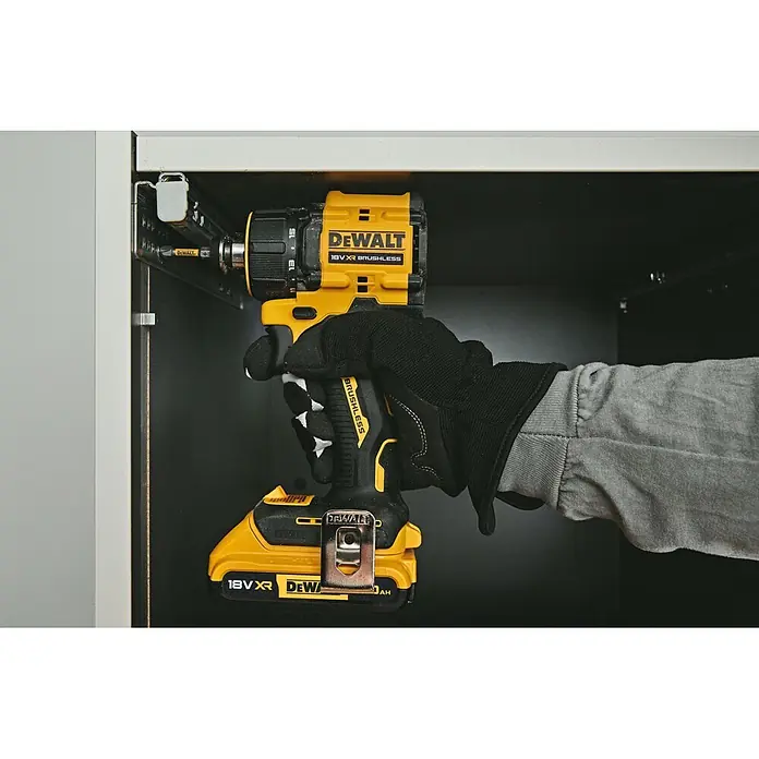 DeWalt XR 18V Taladro atornillador de batería DCD803D2T - 18 V, 2 baterías, 2 Ah, 73 Nm - Taladro/atornillador DeWalt 18V XR Brushless amarillo y negro, sostenido por una mano enguantada, atornillando un riel de gabinete.