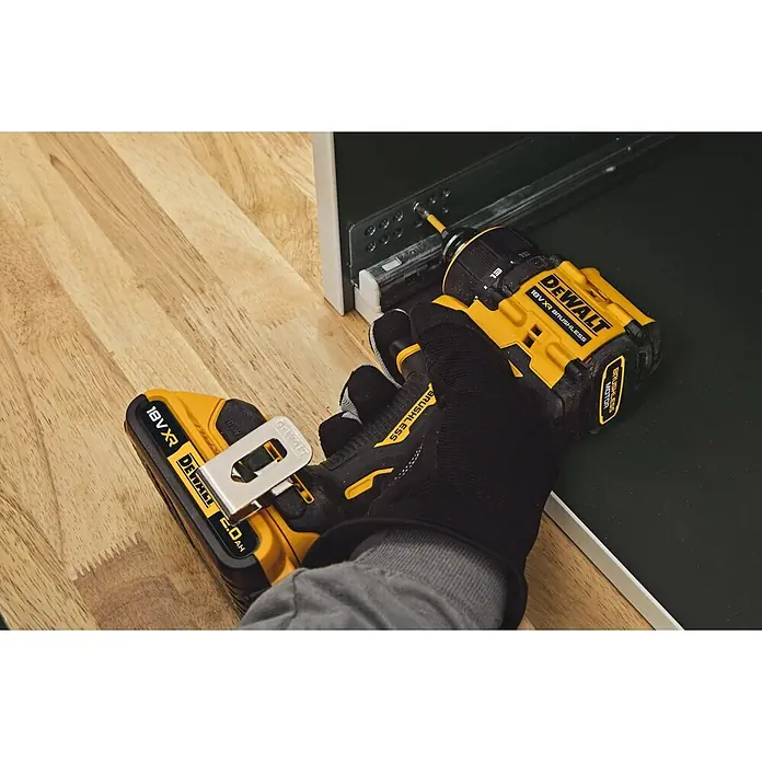 DeWalt XR 18V Taladro atornillador de batería DCD803D2T - 18 V, 2 baterías, 2 Ah, 73 Nm - Una mano enguantada utiliza un destornillador DeWalt 18V XR Brushless amarillo y negro con batería de 2.0Ah para fijar un tornillo en un armario metálico.