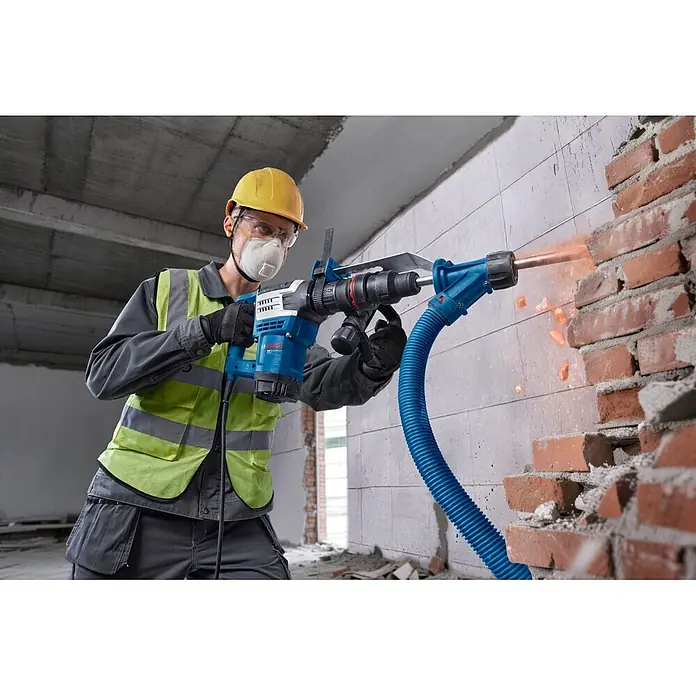 Bosch Professional Schlaghammer GSH5MX - 1.100 W, 7,8 J, Max. Schlagzahl: 2.900 U/min - Blauer Bosch Bohrhammer mit Staubabsaugung bricht eine Ziegelwand.