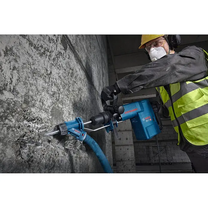 Bosch Professional Schlaghammer GSH 11 EV - 16,8 J, Max. Schlagzahl: 1.890 U/min, SDS-Max-Aufnahme - Bauarbeiter benutzt blauen Boschhammer mit Staubabsaugung an Betonwand.