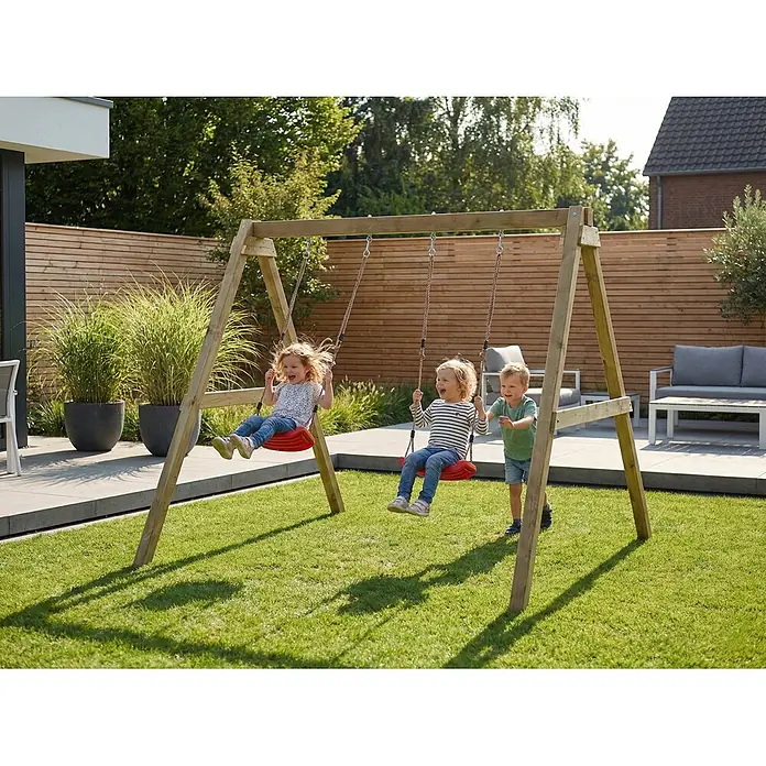 Max Play Schaukel Swing - B x L: 198 x 217 cm, Holz - Hölzerne Schaukel mit roten Sitzen, von drei glücklichen Kindern in einem grünen Garten genutzt.