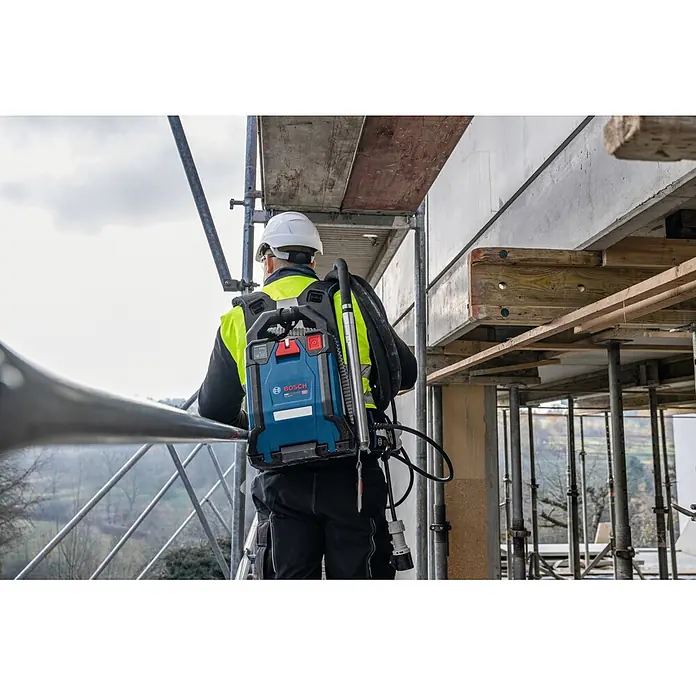 Bosch Professional AMPShare 18V Akku-Antriebseinheit Akku-Betonrüttler-System GPU 18V2DI - 18 V, Anzahl Akkus: Ohne Akku, Anzahl benötigte Akkus: 2 Stk. - Ein Bauarbeiter trägt einen blauen und schwarzen Bosch ProCORE18V Rucksack-Akku auf einem Gerüst.