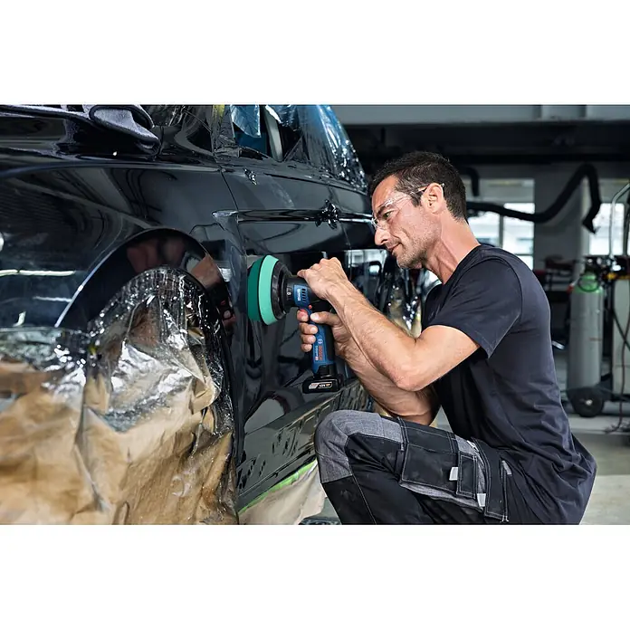 Bosch Professional Akku-Poliermaschine GPX 12V-125 - 12 V, Ohne Akku, Leerlaufdrehzahl: 1.400 U/min - 7.000 U/min - Bosch Akku-Polierer mit grünem Pad, von einem Mann zum Polieren eines schwarzen Autos verwendet.