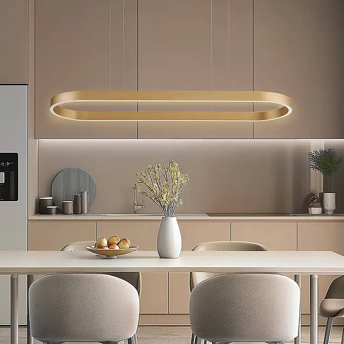 Lucande Pendelleuchte Melinay - L x B x H: 110 x 32 x 4,5 cm, messing / gold, gold - Goldene ovale LED-Pendelleuchte über einem Esstisch in einer modernen Küche.