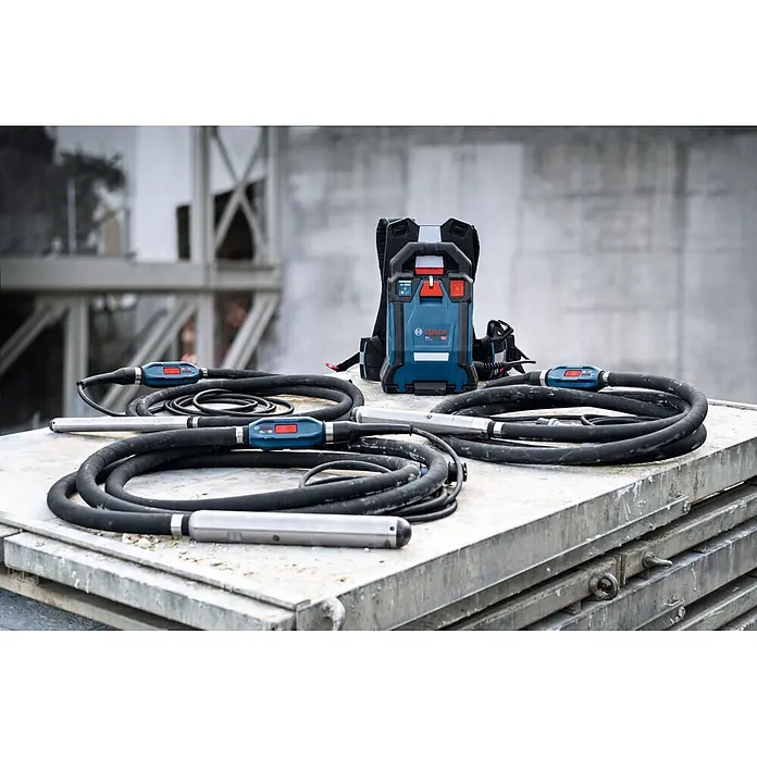 Bosch Professional Innenrüttler Akku-Betonrüttler-System GDI50-500 - Kabellänge: 5 m - Bosch Betonrüttler-System: blaues Rucksack-Netzteil, schwarze Schläuche mit silbernen Rüttelköpfen auf Metallplanken.
