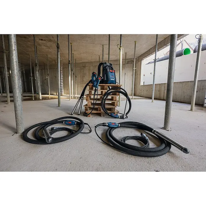 Bosch Professional Innenrüttler Akku-Betonrüttler-System GDI50-500 - Kabellänge: 5 m - Blaues Bosch Betonrüttlersystem mit Akkupack und flexiblen Wellen auf einer Betonbaustelle mit Stützpfosten.