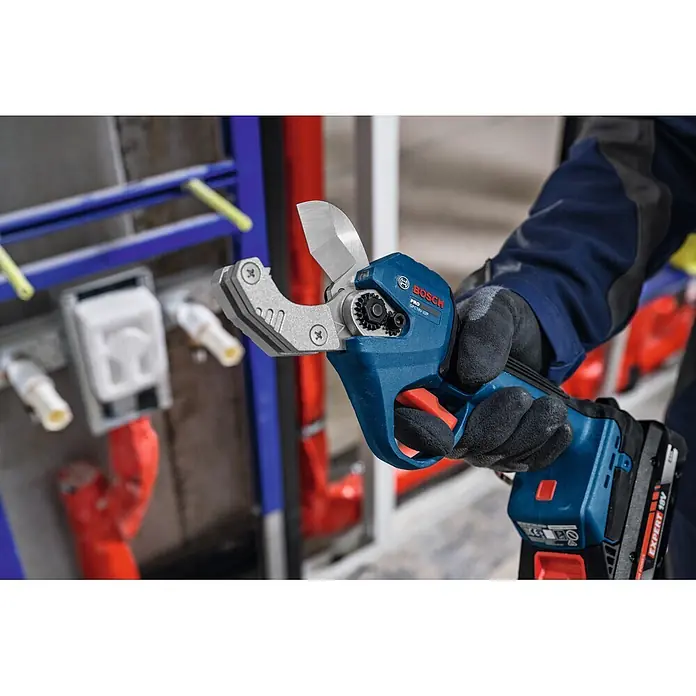 Bosch Professional AMPShare 18V Akku-Rohrschere GPC18V-32P - 18 V, Anzahl Akkus: Ohne Akku, Inkl. L-BOXX 136 - Bosch GRC-18V-32P Rohrschneider mit blauem Gehäuse, schwarzem Griff und rotem Auslöser, von einer behandschuhten Hand im Sanitärbereich gehalten.