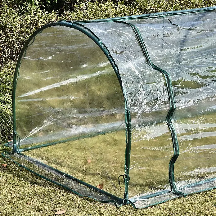Furnicato Gewächshaus - 100 x 250 cm, Material Seitenwand: Stahl, 14 mm, grün - Ein kleines, klares Tunnelgewächshaus aus Kunststoff mit grünem Rahmen und Reißverschlussöffnung, auf grünem Gras im Freien.