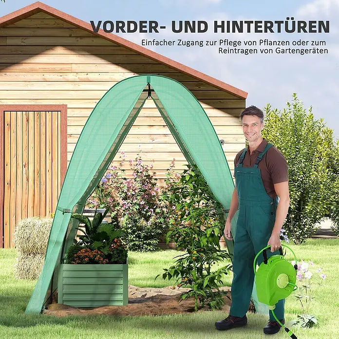 Outsunny Gewächshaus - 180 x 180 cm, Material Seitenwand: Kunststoff, 0,3 mm, Grün - Grünes Bogen-Garten-Gewächshaus im Garten mit Pflanzen; ein Mann in Arbeitskleidung hält einen Schlauchaufroller daneben.