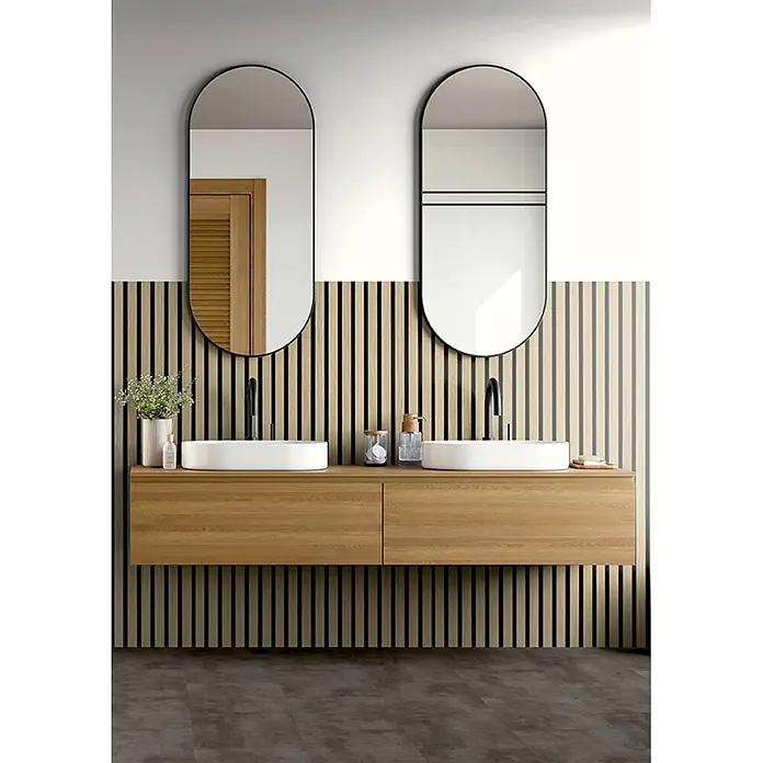 Akustikpaneel Acous Economico - Eiche Hellbraun /schwarzer Filz, 1.200 x 380 x 16,5 mm - Moderner Doppelwaschtisch: heller Holz-Hängeschrank, zwei weiße Aufsatzwaschbecken, schwarze Armaturen, zwei ovale Spiegel vor Lamellenwand.