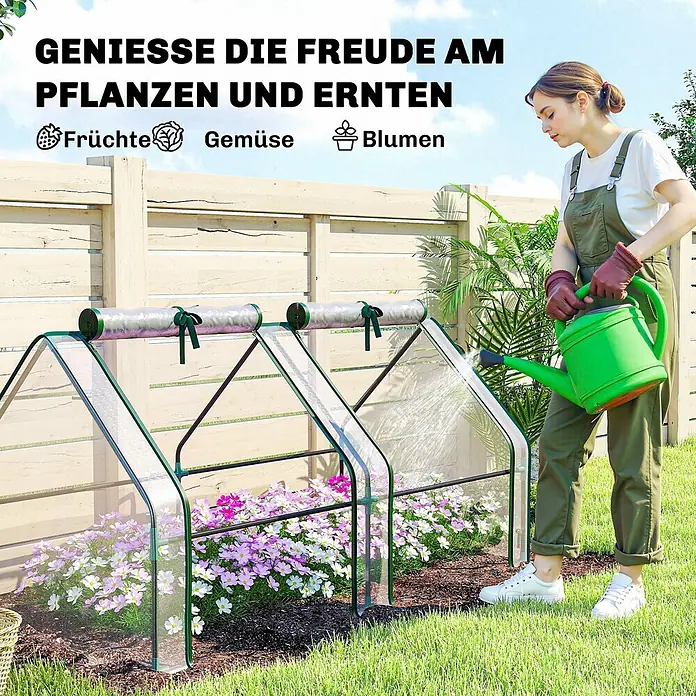 Furnicato Gewächshaus - 90 x 180 cm, Material Seitenwand: Stahl, 14 mm, silber - Zwei kleine, durchsichtige Gewächshäuser mit grünen Rahmen, die blühende Blumen schützen, von einer Frau bewässert.