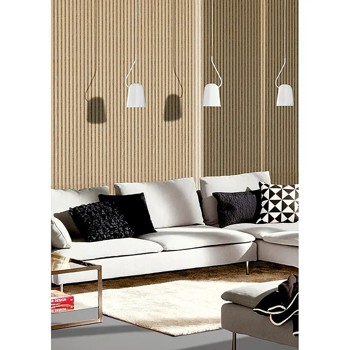 acous Akustikpaneel Economico - Eiche hellbraun / beiger Filz, 2.400 x 380 x 16,5 mm - Drei weiße Pendelleuchten beleuchten ein modernes Wohnzimmer mit einem hellgrauen Modulsofa und schwarzen Zierkissen.
