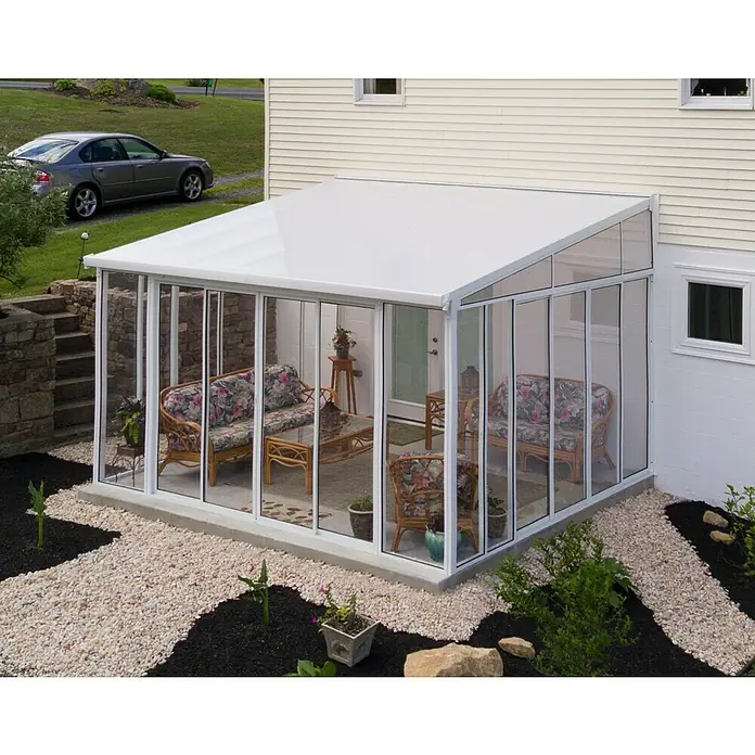 Palram – Canopia Porche acristalado San Remo - An x Pr x Al: 4,25 x 4 x 3,1 m, Blanco tráfico - Una adición de solárium con paredes de vidrio y un techo blanco amplía la casa, ofreciendo un espacio habitable luminoso y confortable.