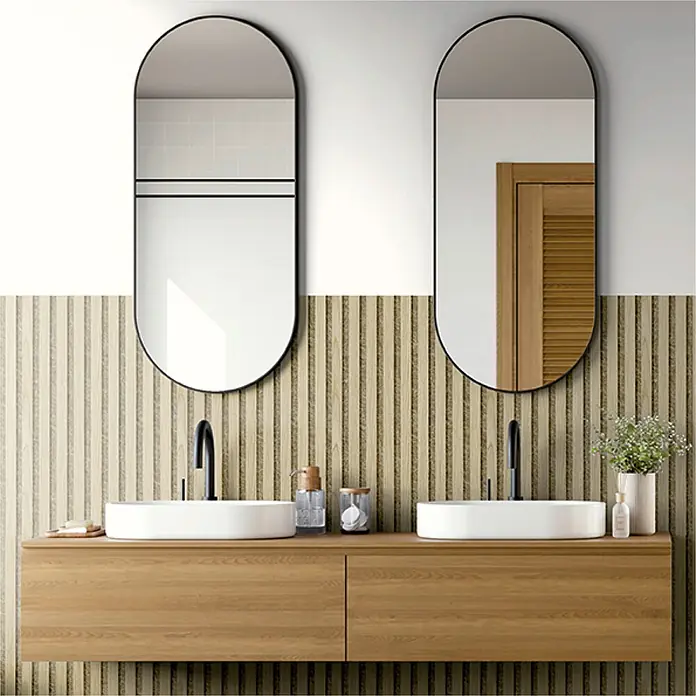 Akustikpaneel Acous Economico - Eiche hellbraun / beiger Filz, 1.200 x 380 x 16,5 mm - Moderne Doppelbadmöbel aus hellem Holz mit zwei weißen Waschbecken, schwarzen Armaturen und zwei schwarz gerahmten, gewölbten Spiegeln.