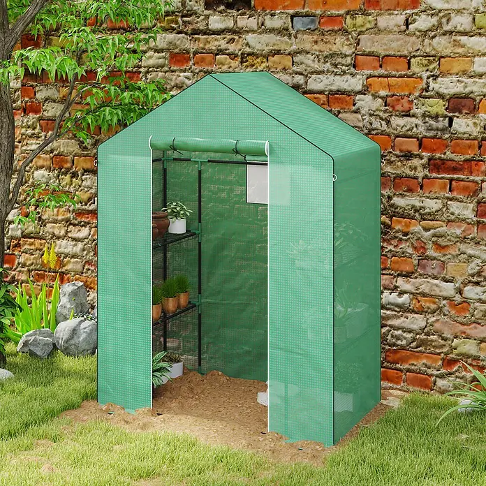 Outsunny Gewächshaus - 143 x 74 cm, Material Seitenwand: Kunststoff, 0,3 mm, Grün - Grünes Stoffgewächshaus mit Rolltür, beherbergt Topfpflanzen, in einem Garten vor einer Ziegelwand.