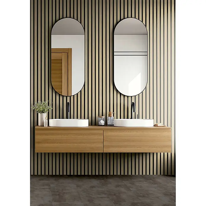 acous Akustikpaneel Economico - Eiche Hellbraun /schwarzer Filz, 2.400 x 380 x 16,5 mm - Doppelter Badwaschtisch mit ovalen Spiegeln, zwei weißen Aufsatzwaschbecken und schwebendem Holzschrank vor Lamellenwand.