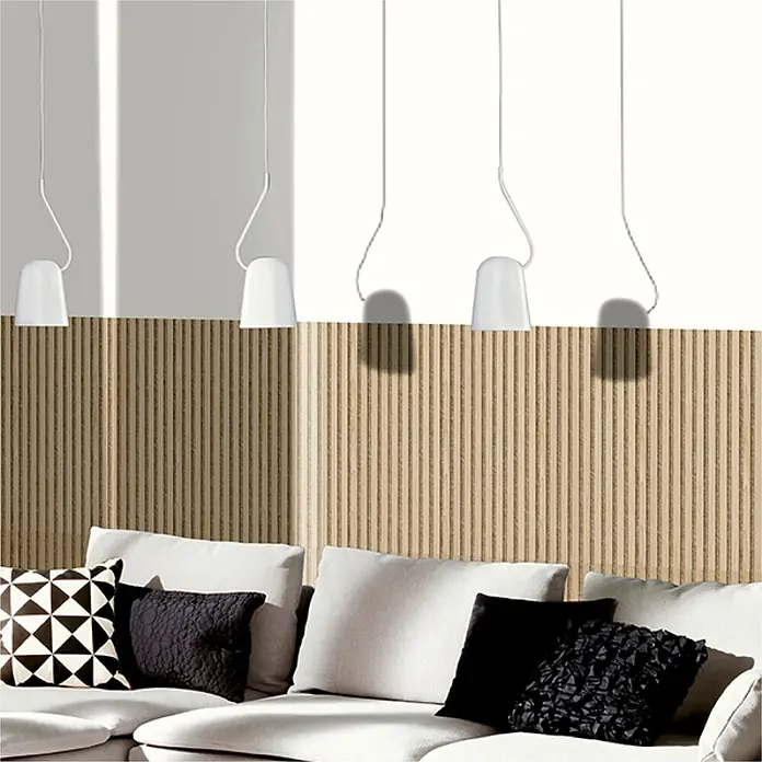 Akustikpaneel Acous Economico - Eiche hellbraun / beiger Filz, 1.200 x 380 x 16,5 mm - Vier weiße Pendelleuchten mit dünnen Kabeln, die über einem grauen Sofa und einer Holzlamellenwand hängen.