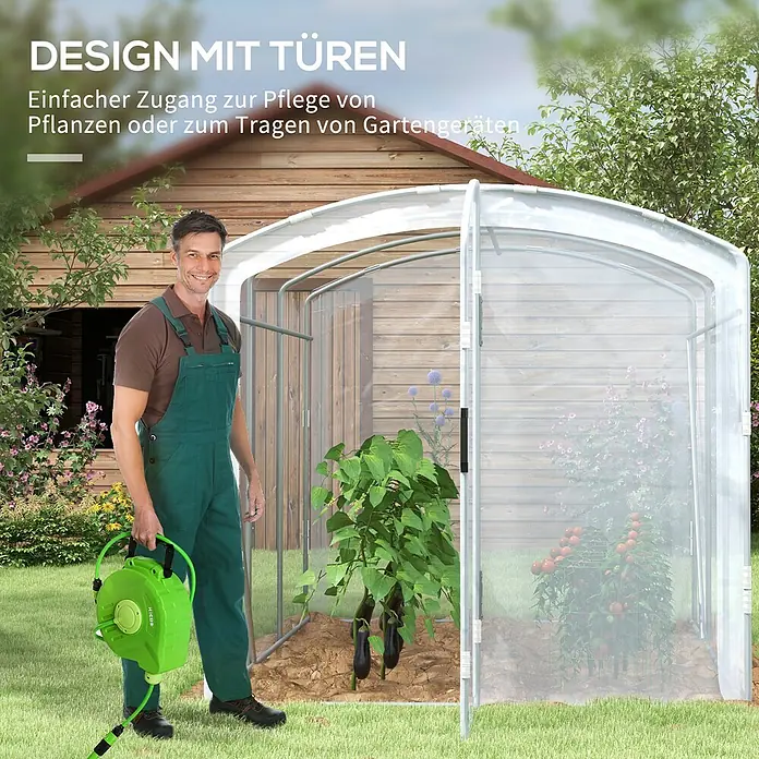 Furnicato Gewächshaus - 200 x 300 cm, Material Seitenwand: Stahl, 14 mm, silber - Mann hält grüne Gartenschlauchrolle vor Gewächshaus mit offenen Türen und Pflanzen.