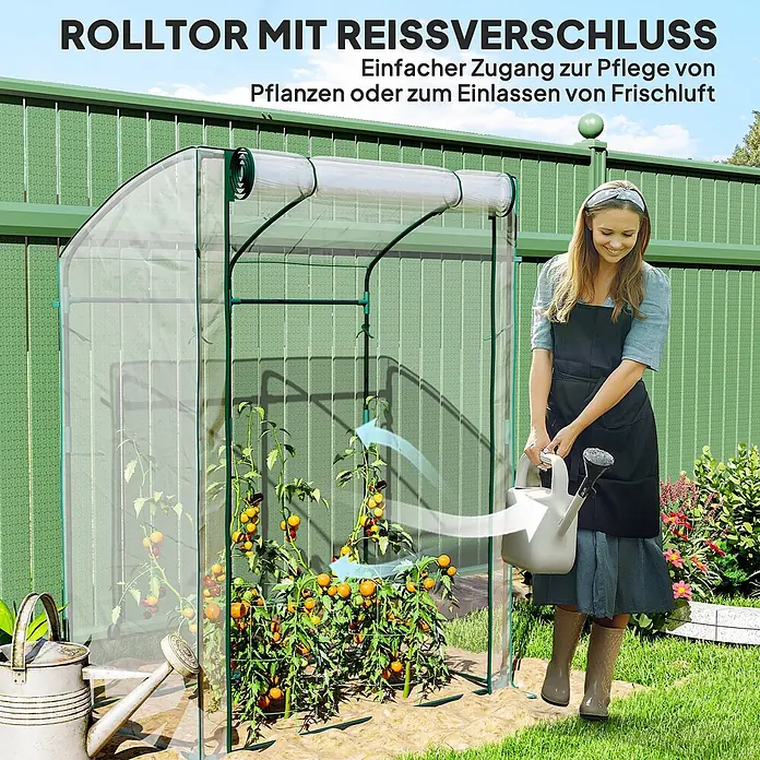 Outsunny Gewächshaus - 128 x 70 cm, Material Seitenwand: Kunststoff, 0,3 mm, Grün - Mini-Gewächshaus mit Reißverschluss-Rolltor, Pflanzen darin. Eine Frau gießt sie, was einfachen Zugang und Belüftung zeigt.